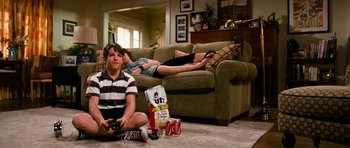 Movie still from “Diary of a Wimpy Kid: Dog Days” (2012), directed by David Bowers – A boy sitting on the floor in front of a couch; Wide shot, High angle