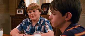 Movie still from “Diary of a Wimpy Kid: Dog Days” (2012), directed by David Bowers – Two young men sitting at a table with a glass of milk; Medium shot, Over the shoulder angle
