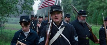Movie still from “Diary of a Wimpy Kid: Dog Days” (2012), directed by David Bowers – A group of men in uniforms holding rifles; Close Up shot, Over the shoulder angle
