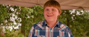 Movie still from “Diary of a Wimpy Kid: Dog Days” (2012), directed by David Bowers – A young boy wearing a blue and red plaid shirt; Close Up shot, Over the shoulder angle