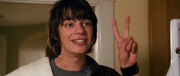 Movie still from “Diary of a Wimpy Kid: Dog Days” (2012), directed by David Bowers – A young man smiling and holding up a peace sign; Close Up shot, Low angle