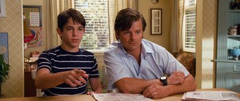 Movie still from “Diary of a Wimpy Kid: Dog Days” (2012), directed by David Bowers – A man sitting at a table next to a young boy; Medium shot, Over the shoulder angle