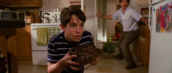 Movie still from “Diary of a Wimpy Kid: Dog Days” (2012), directed by David Bowers – A young man holding a piece of chocolate cake; Medium shot, High angle