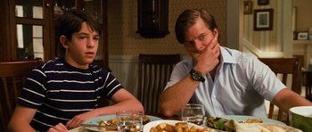 Movie still from “Diary of a Wimpy Kid: Dog Days” (2012), directed by David Bowers – Two men sitting at a dinner table with food; Medium shot, Over the shoulder angle