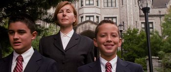 Movie still from “Diary of a Wimpy Kid: Dog Days” (2012), directed by David Bowers – A woman and a young boy wearing suits and ties; Medium shot, Low angle