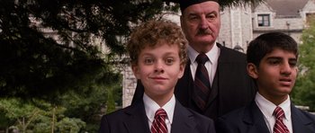 Movie still from “Diary of a Wimpy Kid: Dog Days” (2012), directed by David Bowers – A young boy in a suit and tie next to an older man; Close Up shot, High angle