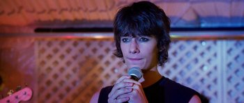 Movie still from “Diary of a Wimpy Kid: Dog Days” (2012), directed by David Bowers – A person holding a microphone in their hand; Close Up shot, Over the shoulder angle