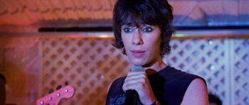 Movie still from “Diary of a Wimpy Kid: Dog Days” (2012), directed by David Bowers – A woman holding a microphone up to her face; Close Up shot, Over the shoulder angle