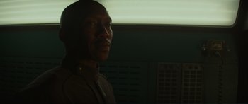 Movie still from “The Hunger Games: Mockingjay - Part 1” (2014), directed by Francis Lawrence – A man in a military uniform looking into the distance; Close Up shot, Over the shoulder angle