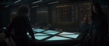 Movie still from “The Hunger Games: Mockingjay - Part 1” (2014), directed by Francis Lawrence – A room that has a table in the middle of the room; Wide shot, Over the shoulder angle