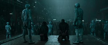 Movie still from “The Hunger Games: Mockingjay - Part 1” (2014), directed by Francis Lawrence – A group of people standing in the middle of a street; Wide shot, High angle