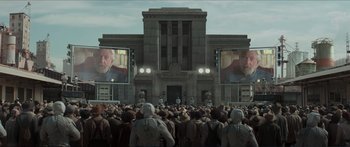 Movie still from “The Hunger Games: Mockingjay - Part 1” (2014), directed by Francis Lawrence – A crowd of people standing in front of a large building; Extreme Wide shot, Low angle