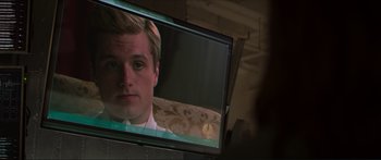 Movie still from “The Hunger Games: Mockingjay - Part 1” (2014), directed by Francis Lawrence – A man is looking at a television screen; Close Up shot, Over the shoulder angle
