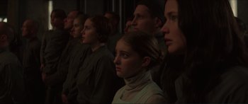 Movie still from “The Hunger Games: Mockingjay - Part 1” (2014), directed by Francis Lawrence – A group of people standing next to each other in a room; Medium shot, Over the shoulder angle