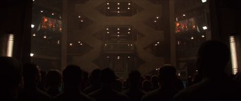 Movie still from “The Hunger Games: Mockingjay - Part 1” (2014), directed by Francis Lawrence – A group of people sitting in front of a building; Extreme Wide shot, Low angle