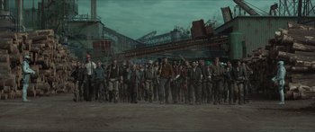 Movie still from “The Hunger Games: Mockingjay - Part 1” (2014), directed by Francis Lawrence – A group of people standing next to each other on a dirt field; Extreme Wide shot, High angle