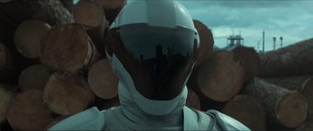 Movie still from “The Hunger Games: Mockingjay - Part 1” (2014), directed by Francis Lawrence – A person wearing a helmet and standing in front of a pile of wood; Close Up shot, Over the shoulder angle