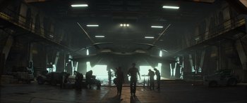 Movie still from “The Hunger Games: Mockingjay - Part 1” (2014), directed by Francis Lawrence – A group of people standing in front of an airplane; Extreme Wide shot, Low angle