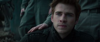 Movie still from “The Hunger Games: Mockingjay - Part 1” (2014), directed by Francis Lawrence – A person with his arm around another person; Close Up shot, Over the shoulder angle