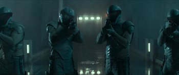 Movie still from “The Hunger Games: Mockingjay - Part 1” (2014), directed by Francis Lawrence – A couple of men standing next to each other in a room; Medium shot, Low angle