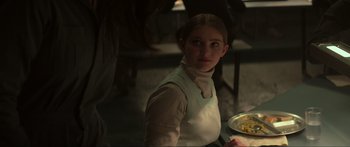 Movie still from “The Hunger Games: Mockingjay - Part 1” (2014), directed by Francis Lawrence – A woman in a white apron holding a plate of food; Close Up shot, Over the shoulder angle