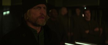 Movie still from “The Hunger Games: Mockingjay - Part 1” (2014), directed by Francis Lawrence – A person wearing a jacket and a hat; Close Up shot, Over the shoulder angle