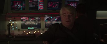 Movie still from “The Hunger Games: Mockingjay - Part 1” (2014), directed by Francis Lawrence – A man sitting in front of multiple monitors; Close Up shot, Over the shoulder angle