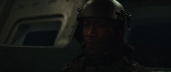 Movie still from “The Hunger Games: Mockingjay - Part 1” (2014), directed by Francis Lawrence – A man wearing a helmet in a dark room; Close Up shot, Over the shoulder angle