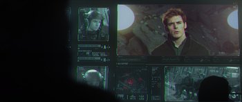 Movie still from “The Hunger Games: Mockingjay - Part 1” (2014), directed by Francis Lawrence – A computer screen showing a man in a black jacket; Extreme Close Up shot, Over the shoulder angle