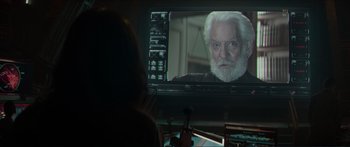 Movie still from “The Hunger Games: Mockingjay - Part 1” (2014), directed by Francis Lawrence – A person sitting in front of a television; Close Up shot, Over the shoulder angle