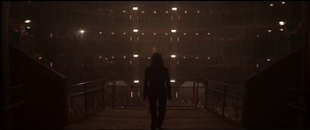 Movie still from “The Hunger Games: Mockingjay - Part 1” (2014), directed by Francis Lawrence – A person standing in a dark room with lights on; Extreme Wide shot, High angle