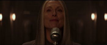 Movie still from “The Hunger Games: Mockingjay - Part 1” (2014), directed by Francis Lawrence – A woman with long blonde hair is holding a microphone; Close Up shot, Low angle