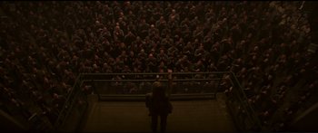 Movie still from “The Hunger Games: Mockingjay - Part 1” (2014), directed by Francis Lawrence – A crowd of people standing in front of a fence; Extreme Wide shot, Overhead angle