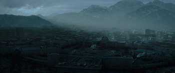 Movie still from “The Hunger Games: Mockingjay - Part 2” (2015), directed by Francis Lawrence – An aerial view of a city with a mountain in the background; Extreme Wide shot, High angle