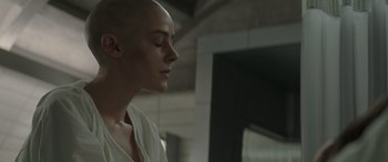 Movie still from “The Hunger Games: Mockingjay - Part 2” (2015), directed by Francis Lawrence – A woman with a shaved head is looking down; Close Up shot, Low angle