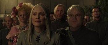 Movie still from “The Hunger Games: Mockingjay - Part 2” (2015), directed by Francis Lawrence – A group of people sitting next to each other in a room; Close Up shot, Low angle