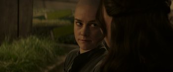 Movie still from “The Hunger Games: Mockingjay - Part 2” (2015), directed by Francis Lawrence – A woman with a shaved head looking into the camera; Close Up shot, Over the shoulder angle