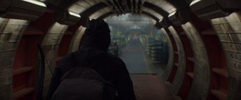 Movie still from “The Hunger Games: Mockingjay - Part 2” (2015), directed by Francis Lawrence – A person with a backpack walking through a tunnel; Wide shot, Low angle