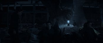 Movie still from “The Hunger Games: Mockingjay - Part 2” (2015), directed by Francis Lawrence – A man sitting in a chair in a dark room; Wide shot, High angle
