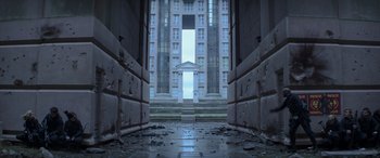 Movie still from “The Hunger Games: Mockingjay - Part 2” (2015), directed by Francis Lawrence – An old building with a very tall building in the background; Extreme Wide shot, Low angle