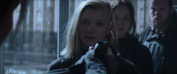 Movie still from “The Hunger Games: Mockingjay - Part 2” (2015), directed by Francis Lawrence – A woman holding a gun in front of another woman; Close Up shot, Over the shoulder angle
