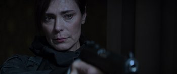 Movie still from “The Hunger Games: Mockingjay - Part 2” (2015), directed by Francis Lawrence – A woman holding a gun in a dark room; Close Up shot, Low angle