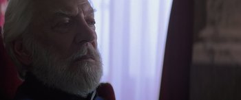 Movie still from “The Hunger Games: Mockingjay - Part 2” (2015), directed by Francis Lawrence – An old man with a beard looking at the camera; Close Up shot, Over the shoulder angle