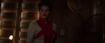 Movie still from “The Hunger Games: Mockingjay - Part 2” (2015), directed by Francis Lawrence – A woman wearing a red and white jacket and tie; Medium shot, Low angle