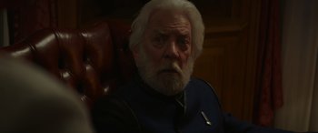 Movie still from “The Hunger Games: Mockingjay - Part 2” (2015), directed by Francis Lawrence – An old man with white hair sitting in a chair; Close Up shot, Over the shoulder angle