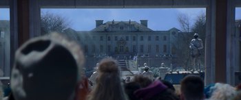 Movie still from “The Hunger Games: Mockingjay - Part 2” (2015), directed by Francis Lawrence – A group of people standing in front of a large building; Extreme Wide shot, Low angle