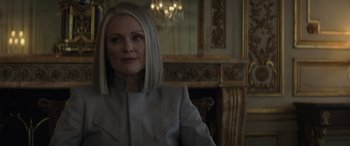 Movie still from “The Hunger Games: Mockingjay - Part 2” (2015), directed by Francis Lawrence – A woman in a white jacket sitting in a chair; Close Up shot, Over the shoulder angle