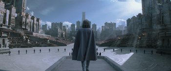 Movie still from “The Hunger Games: Mockingjay - Part 2” (2015), directed by Francis Lawrence – A man in a cape is standing in front of a city; Extreme Wide shot, High angle