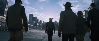 Movie still from “The Hunger Games: Mockingjay - Part 2” (2015), directed by Francis Lawrence – A man and a woman walking down a street; Wide shot, Low angle