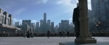 Movie still from “The Hunger Games: Mockingjay - Part 2” (2015), directed by Francis Lawrence – A group of people standing in front of tall buildings; Extreme Wide shot, Low angle